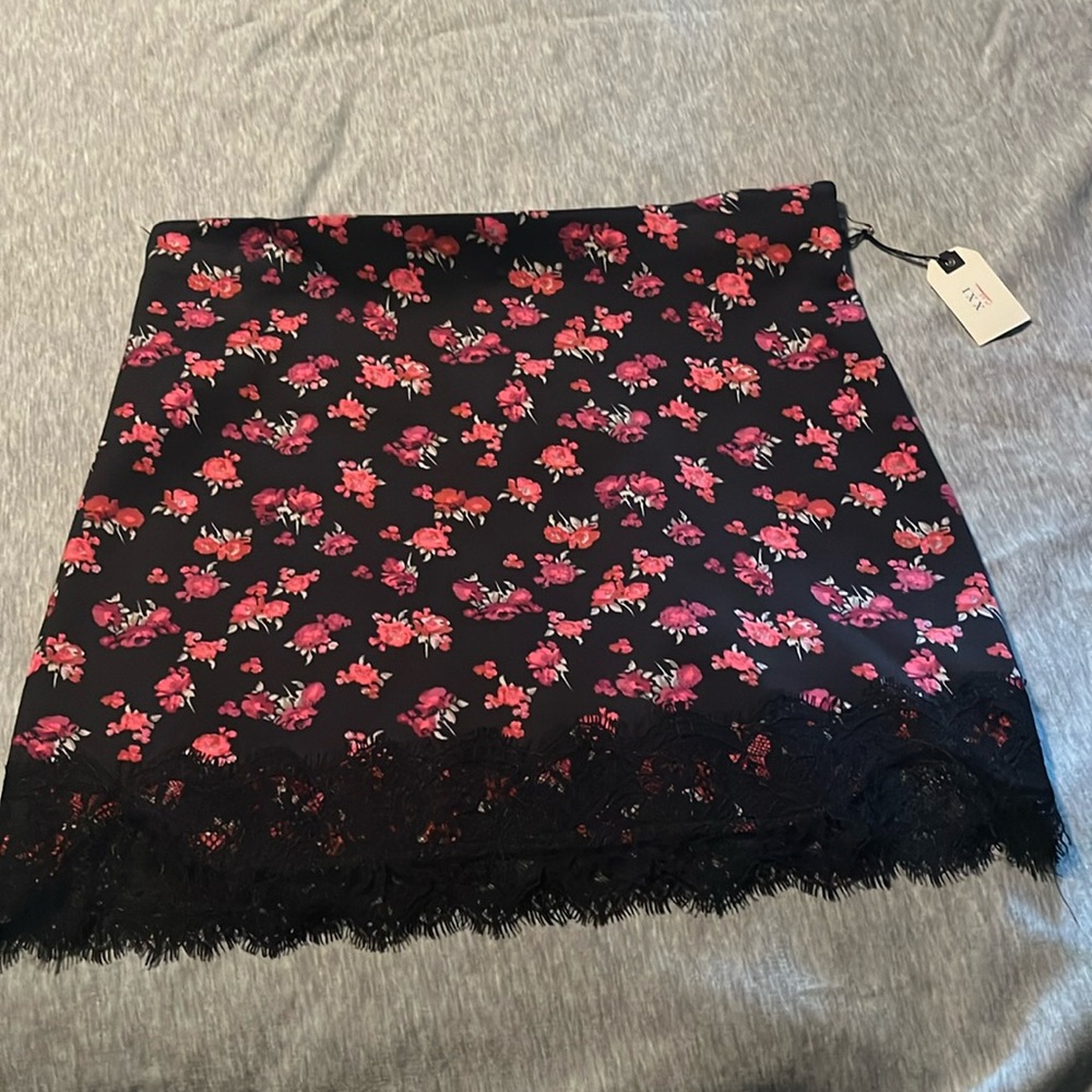 Mini black skirt with pink and purple flowers and lace trim detail.